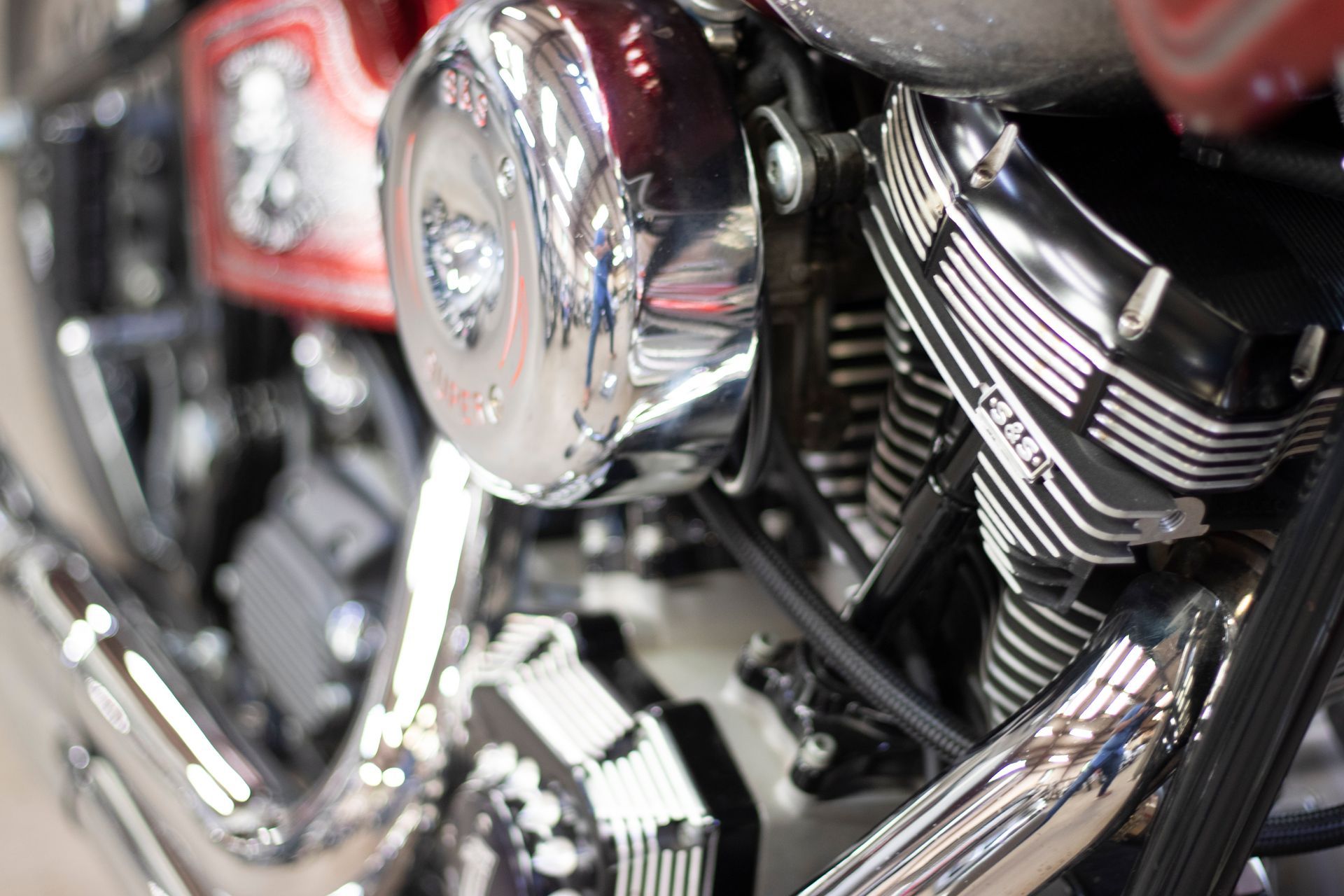 Black motorcycle with red handlebars, parked indoors.