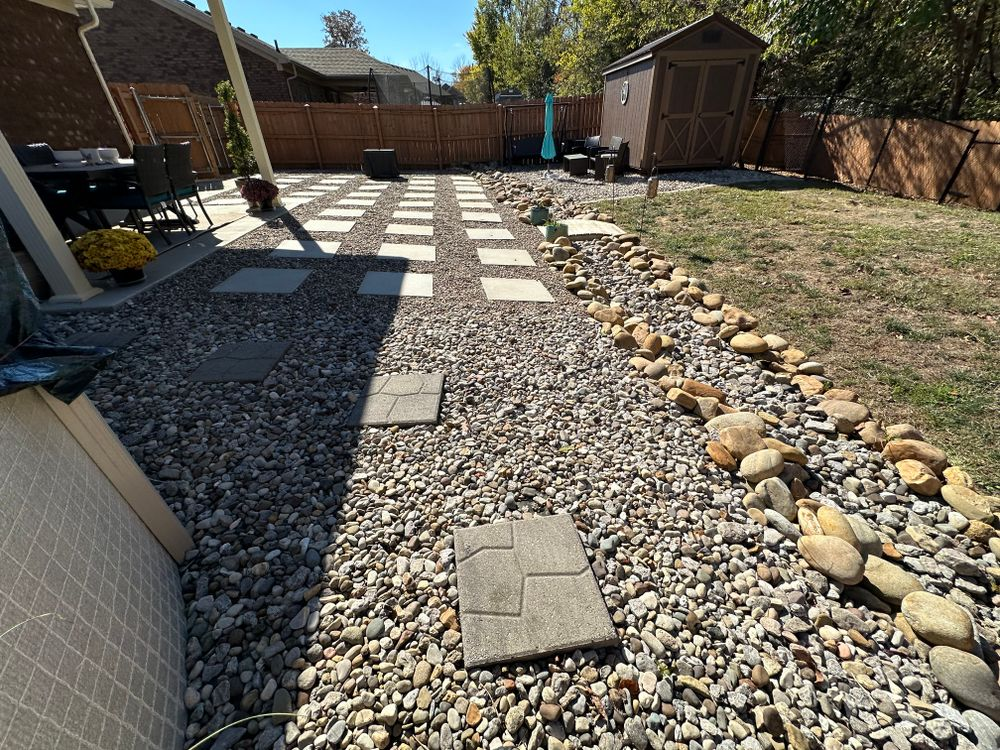 A gravel path in a backyard with a shed in the background.