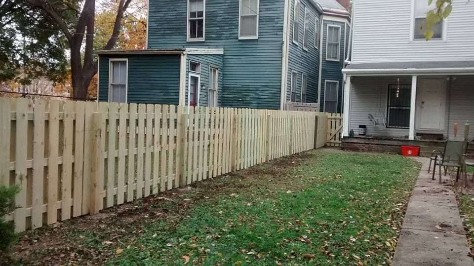 There is a wooden fence in the backyard of a house.