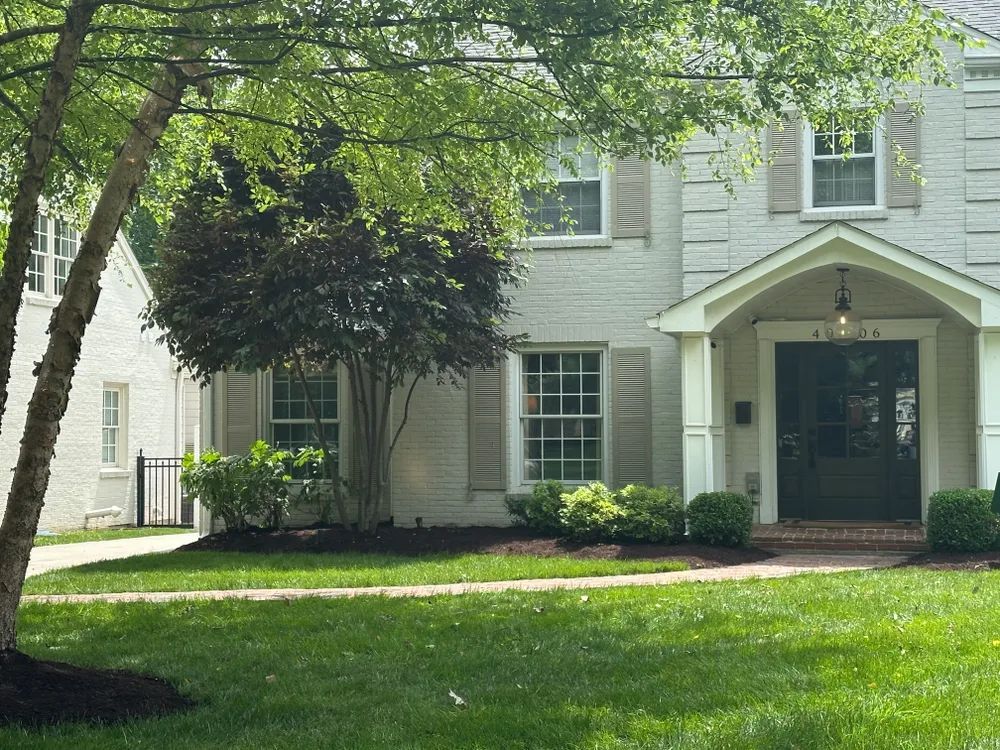 A white house with a black door and a porch