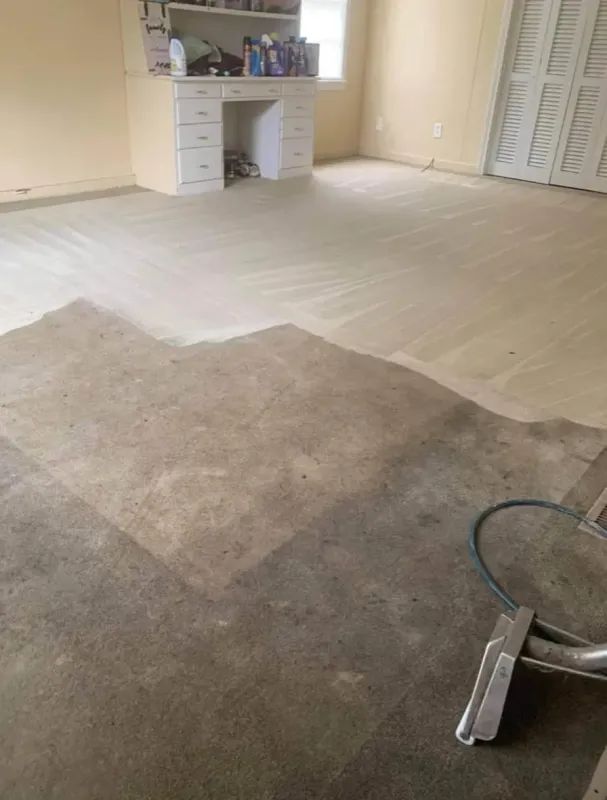 Wooden floor partially sanded and refinished, revealing lighter and darker areas in a room with a cabinet.