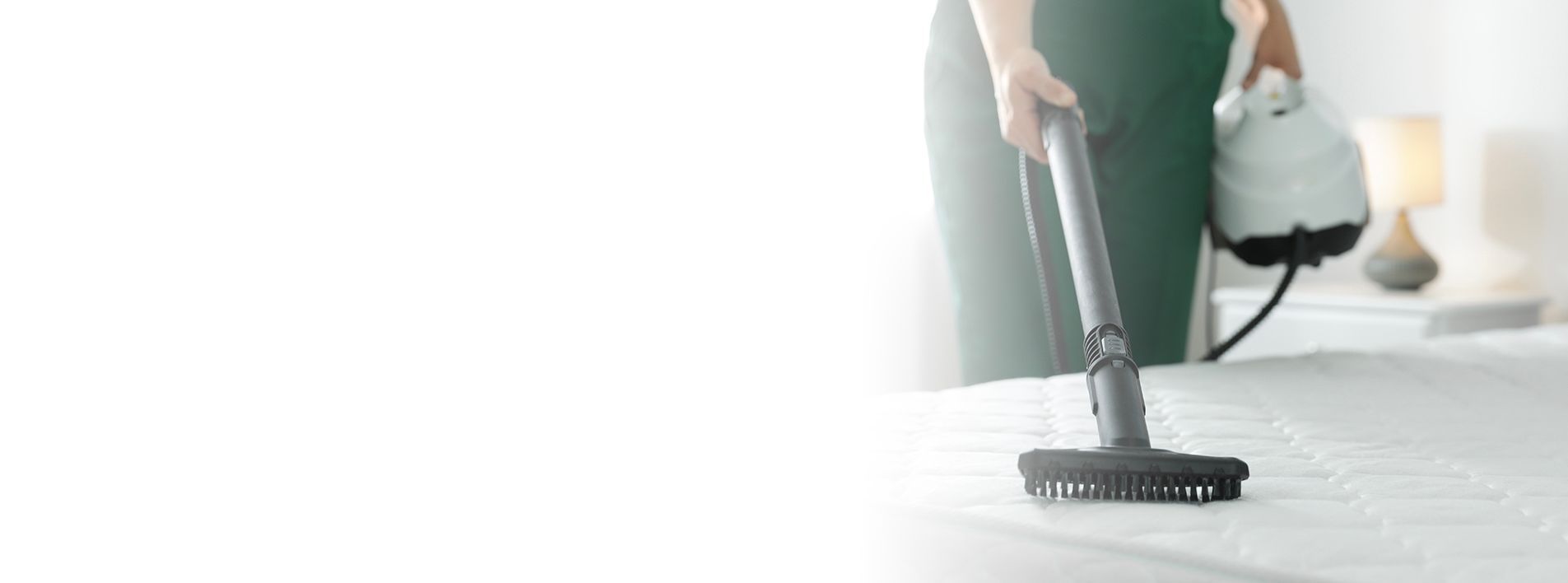 Person using a steam cleaner on a bed. Person using a steam cleaner on a bed.