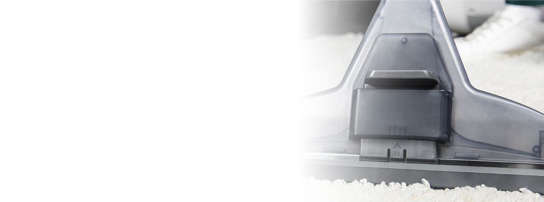 Close-up of a vacuum cleaner head on a white rug. Close-up of a vacuum cleaner head on a white rug.