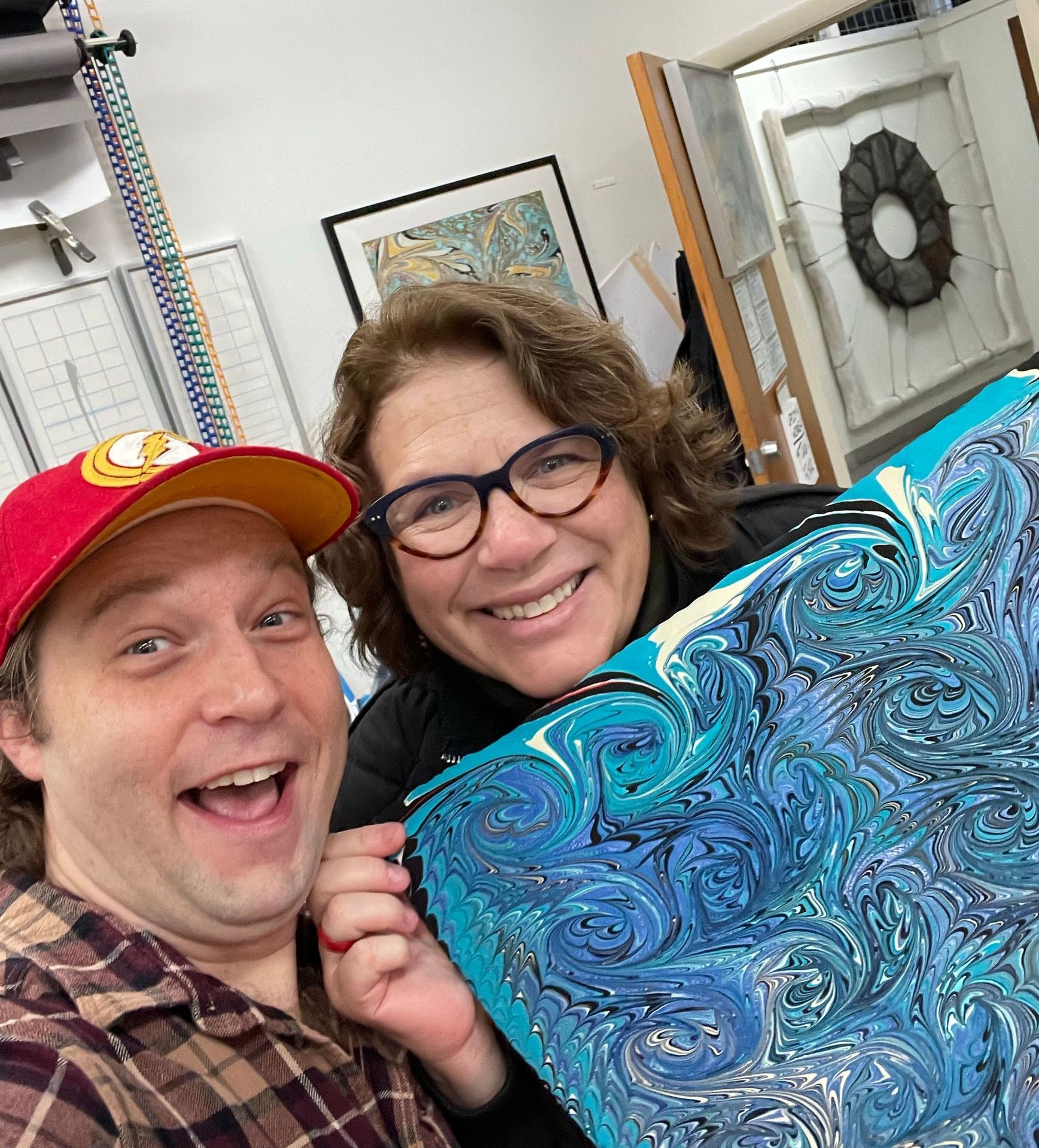 Teacher Keith Garubba poses in a selfie with private student who holds her artwork with a smile.