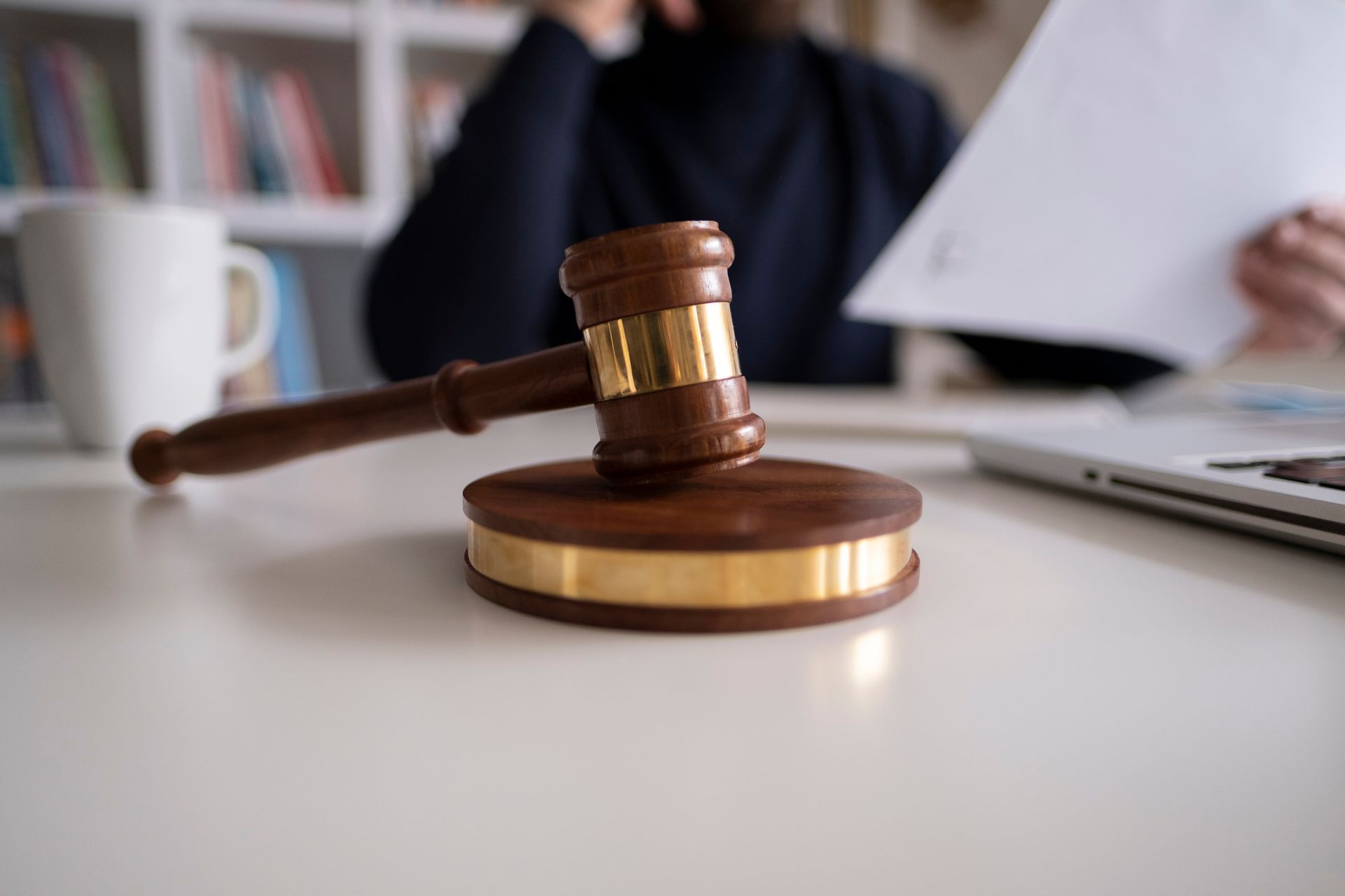 A judge 's gavel is sitting on a table next to a laptop.