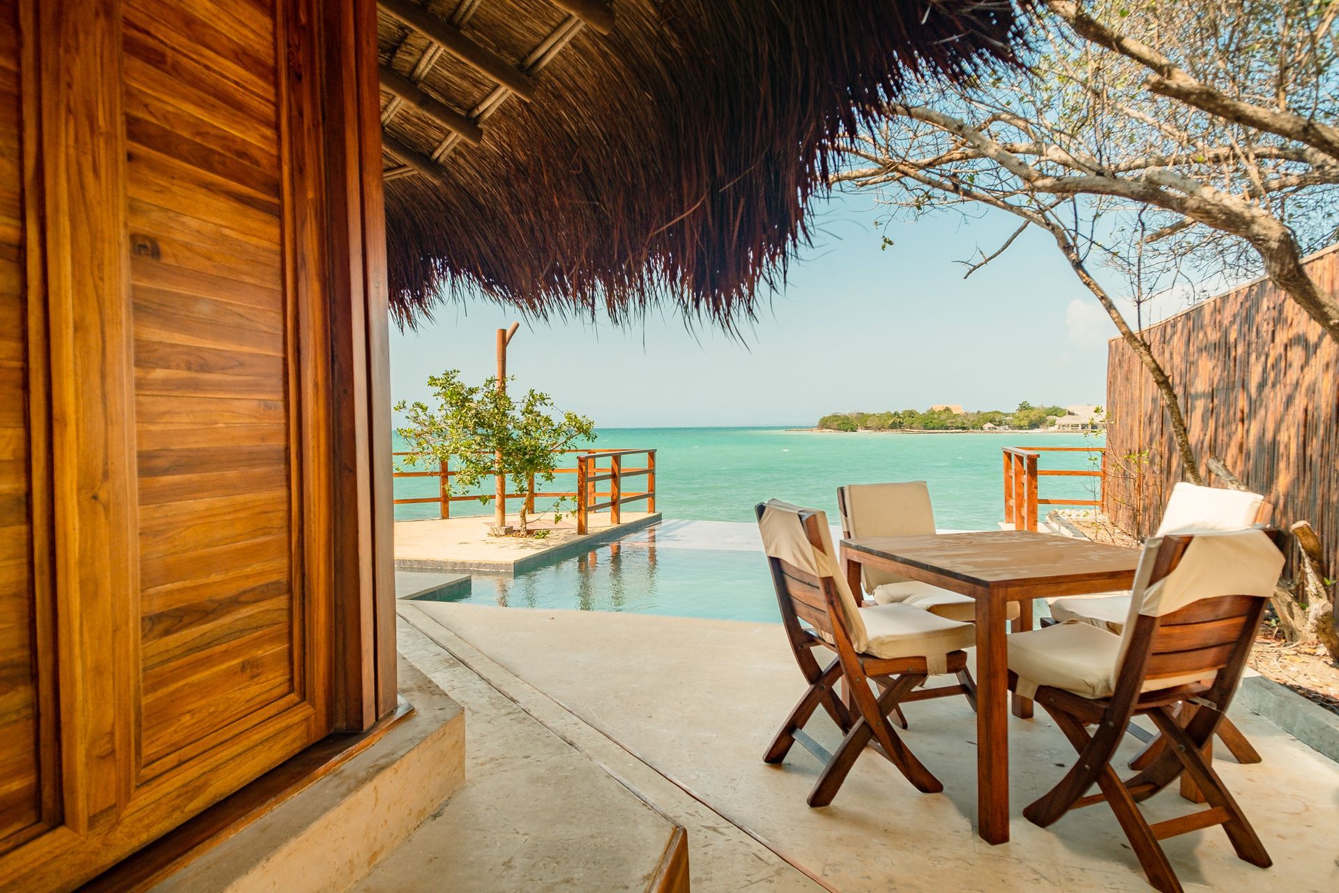 Terraza con mesa, piscina y vista al mar Caribe en Hotel Las Islas, Barú.