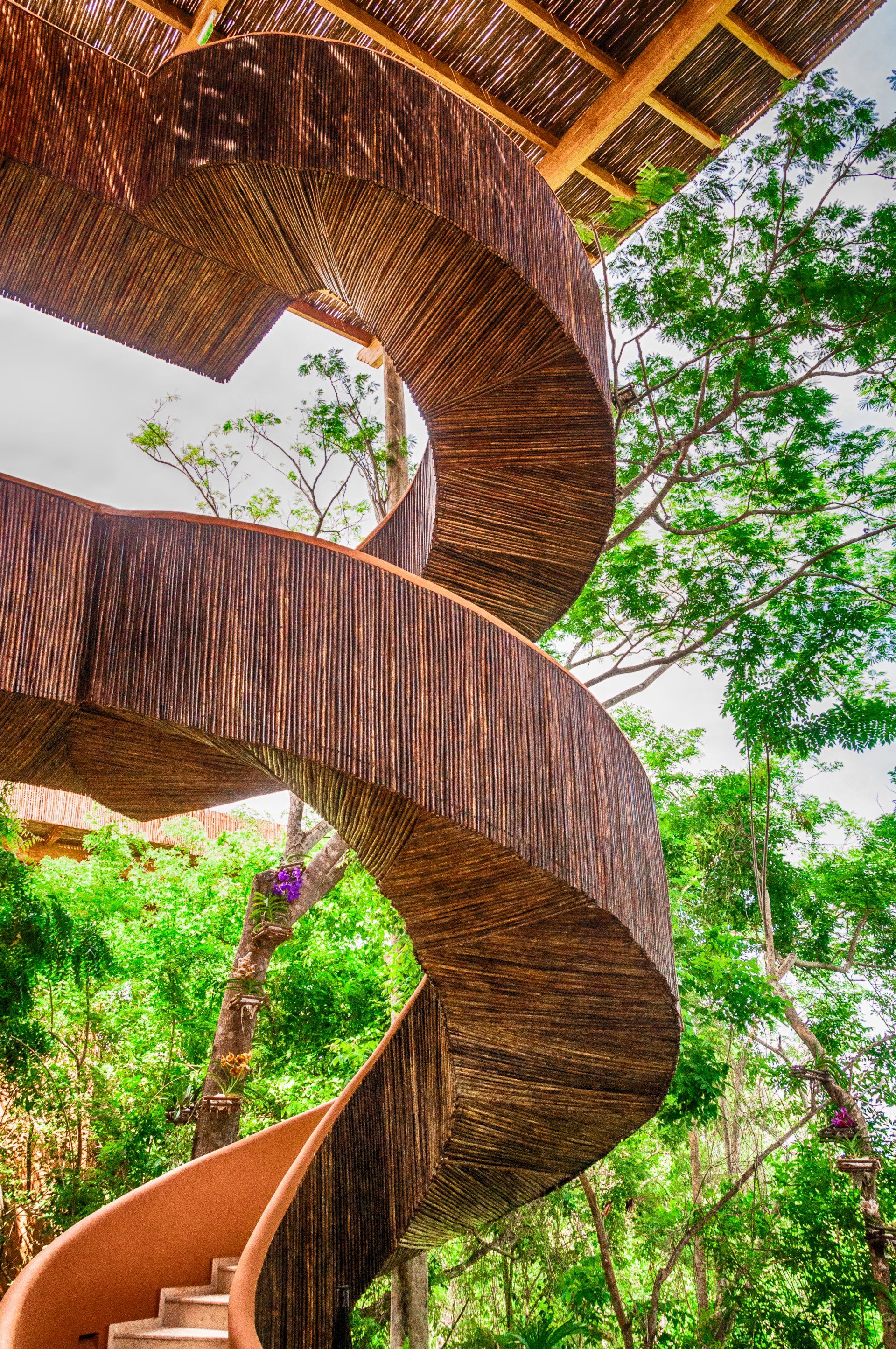 Acceso al Club House mediante una escalera caracol en un entorno natural en Hotel Las Islas