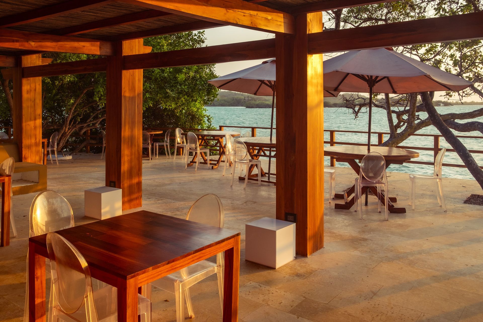 Zona social en la Isleta de Hotel Las Islas, Isla Barú, con mesas al aire libre y vistas al mar Caribe