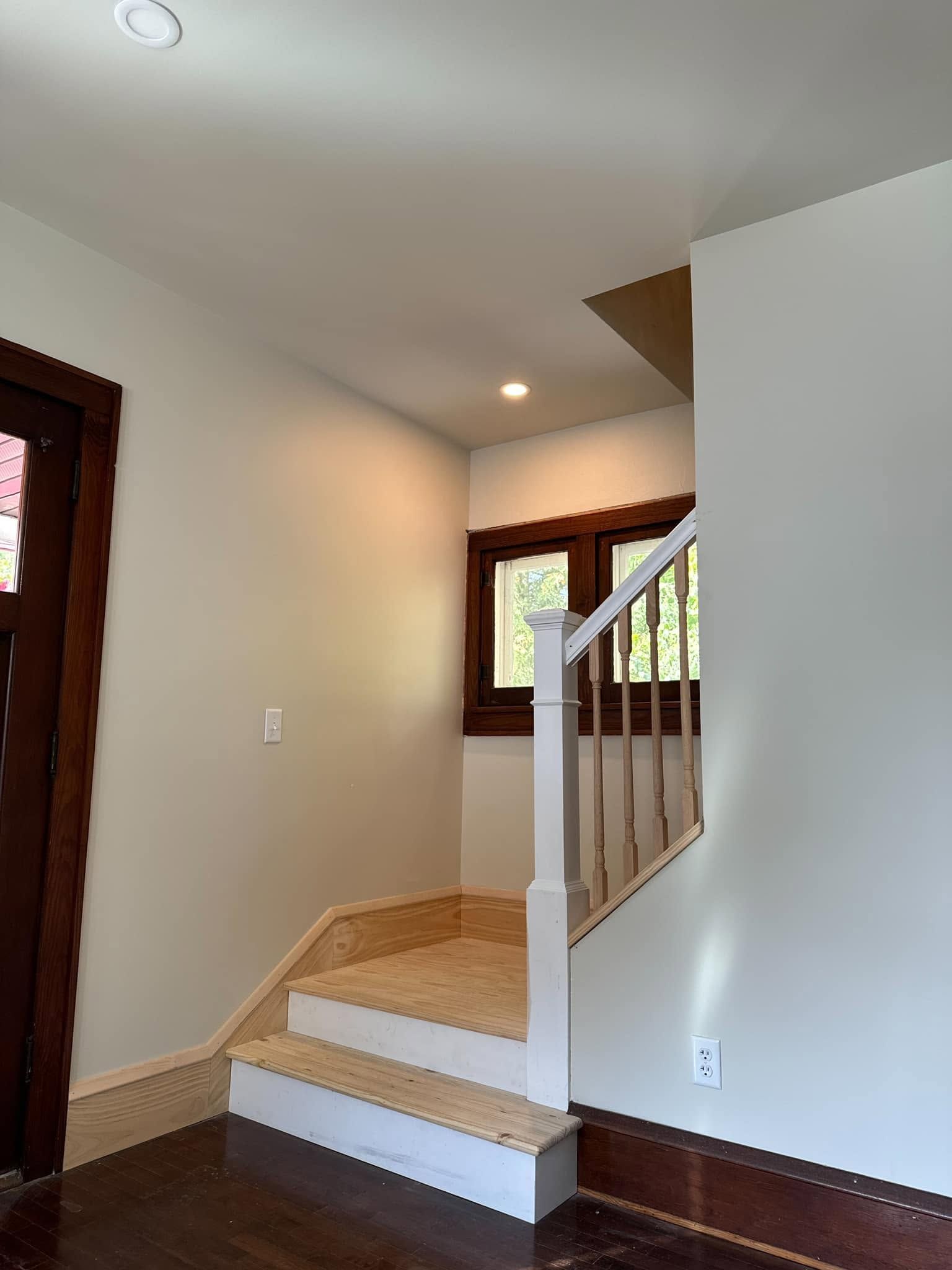 Staircase landing with tan carpet, white railing, and beige walls in a home interior
