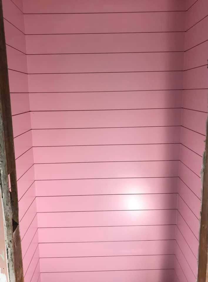 Pink paneled wall with a bright light reflection in the center
