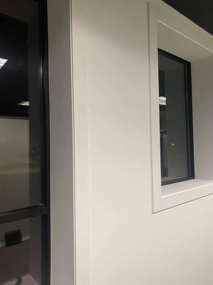 White wall with two black-framed windows indoors