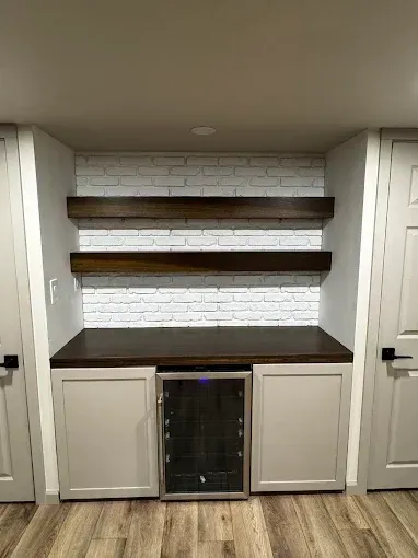 Built-in shelving and cabinets with a wine fridge in a recessed wall nook