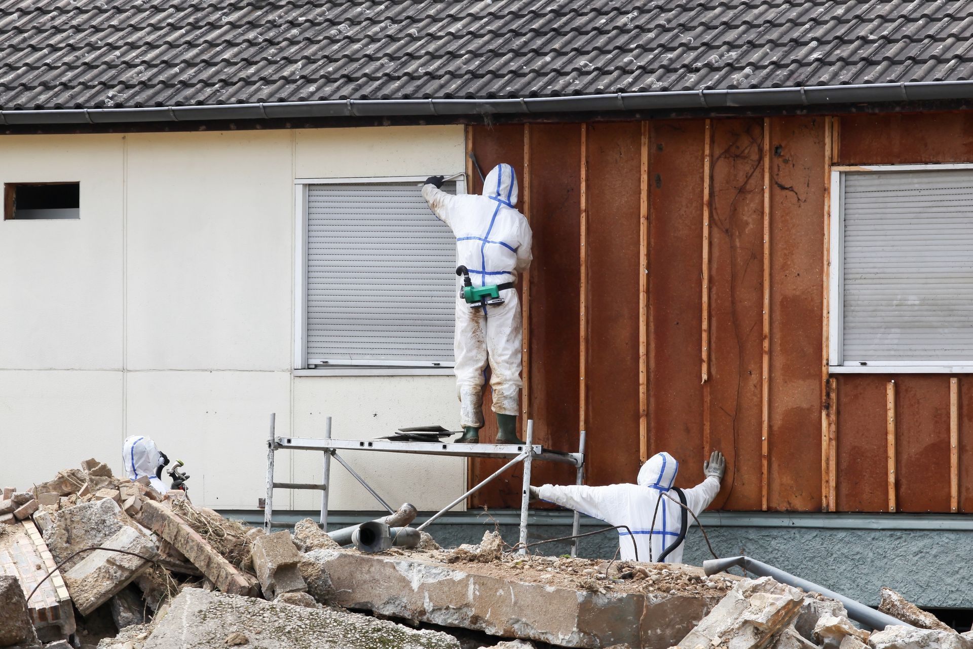 Two men are conducting asbestos removal from a house.