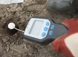 a person is holding a digital checker testing the land