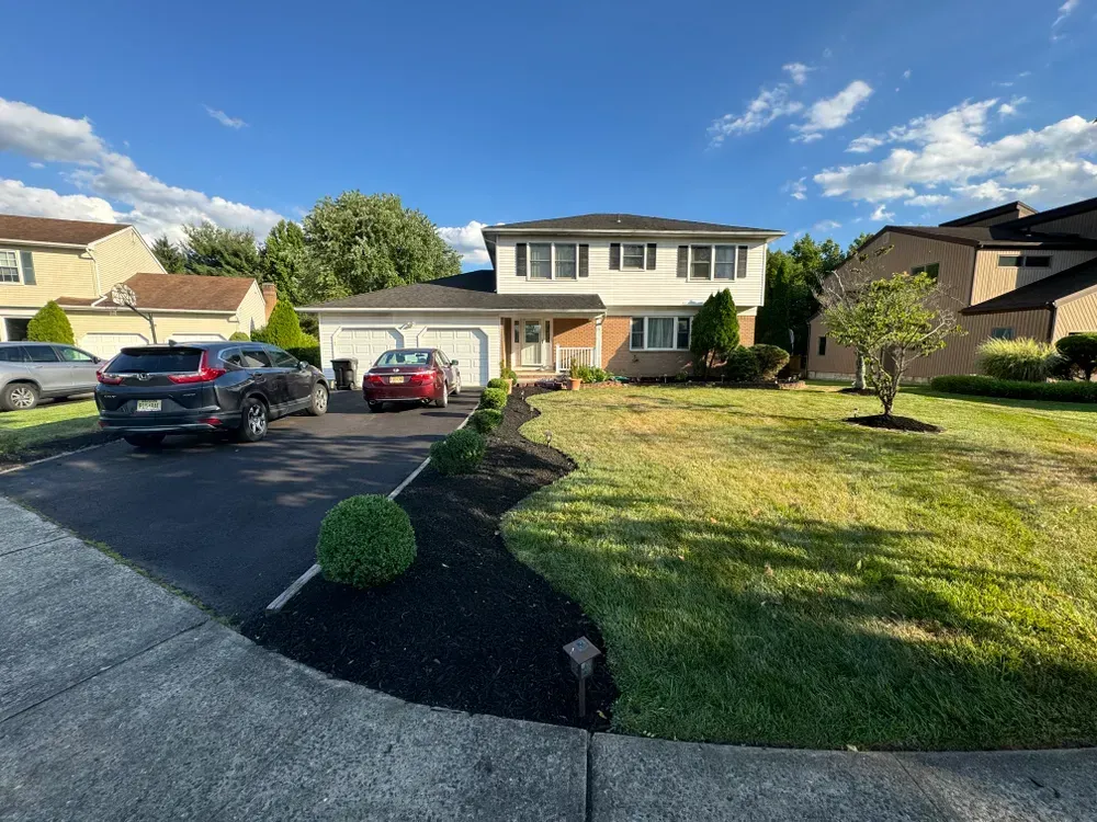 A couple of cars are parked in front of a house.