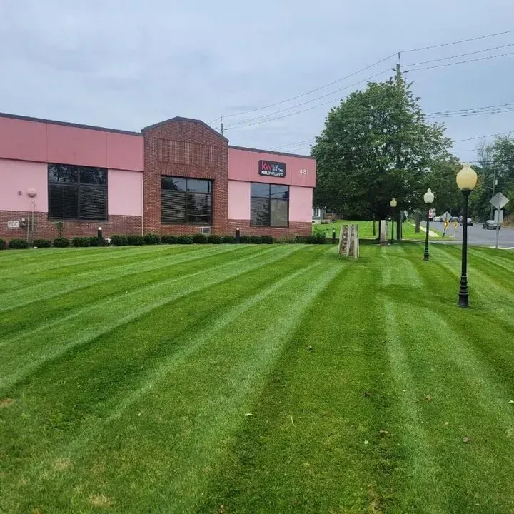 A large building with a lush green lawn in front of it.