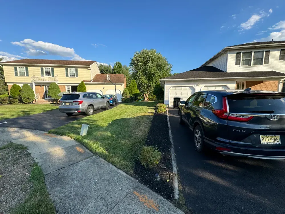 A black car is parked in front of a house.