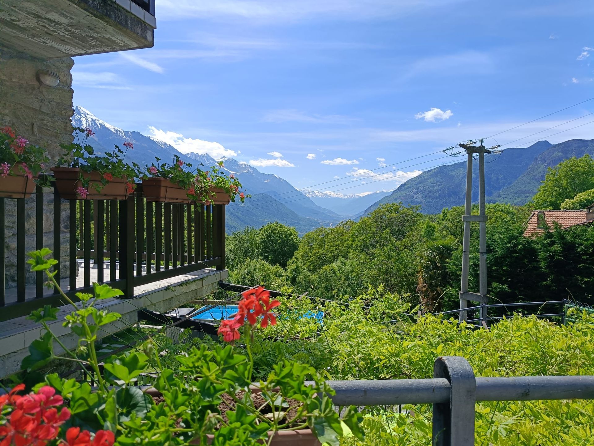 Panoramic view of the Aosta Valley from the bedroom balcony, overlooking mountains, forests and picturesque alpine landscapes.