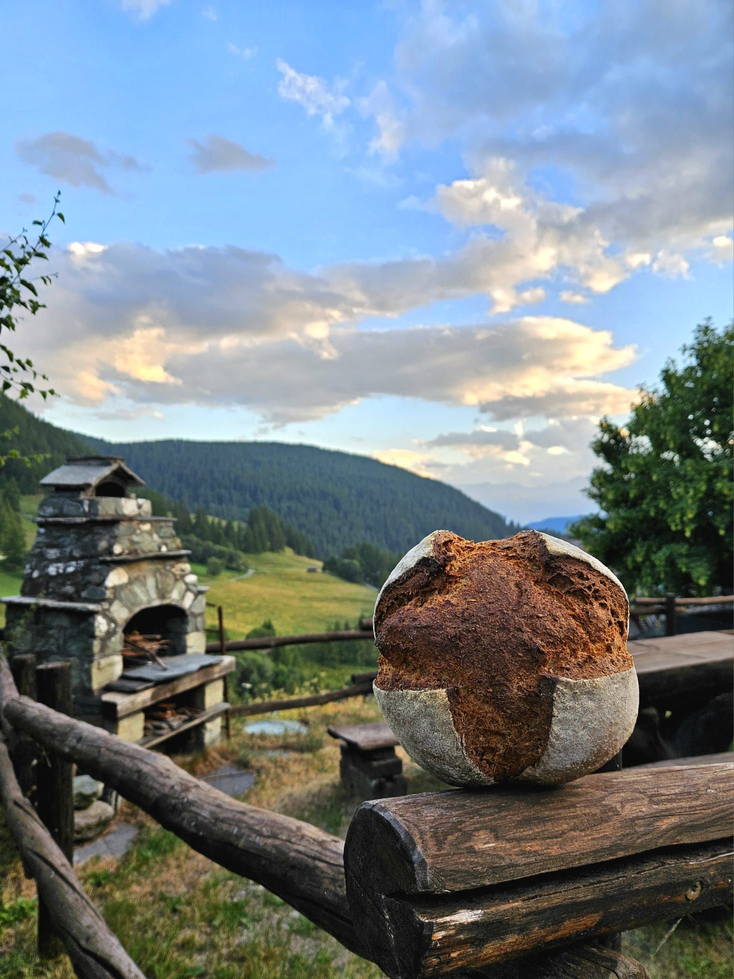 Artisan bread from the Liussel wood-fired oven in the foreground with Chamois village and the Matterhorn in the background, Aosta Valley