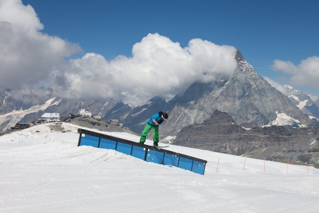 Snowboarder in azione sulle nevi estive di Cervinia con il Cervino ben visibile all’orizzonte