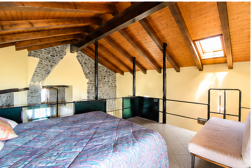 Cozy sleeping loft created within the restored historic hay barn, featuring original wooden beams and authentic alpine charm.