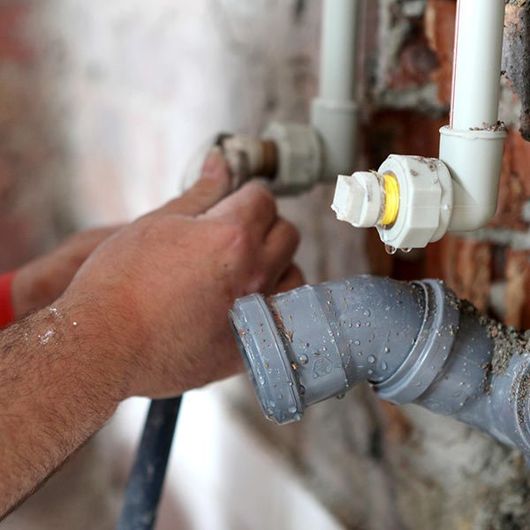 Plumber Working on Pipes — Plainview, NY — Martino Plumbing & Heating INC.