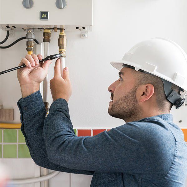 Repairman Installing a Natural Gas Boiler — Plainview, NY — Martino Plumbing & Heating INC.