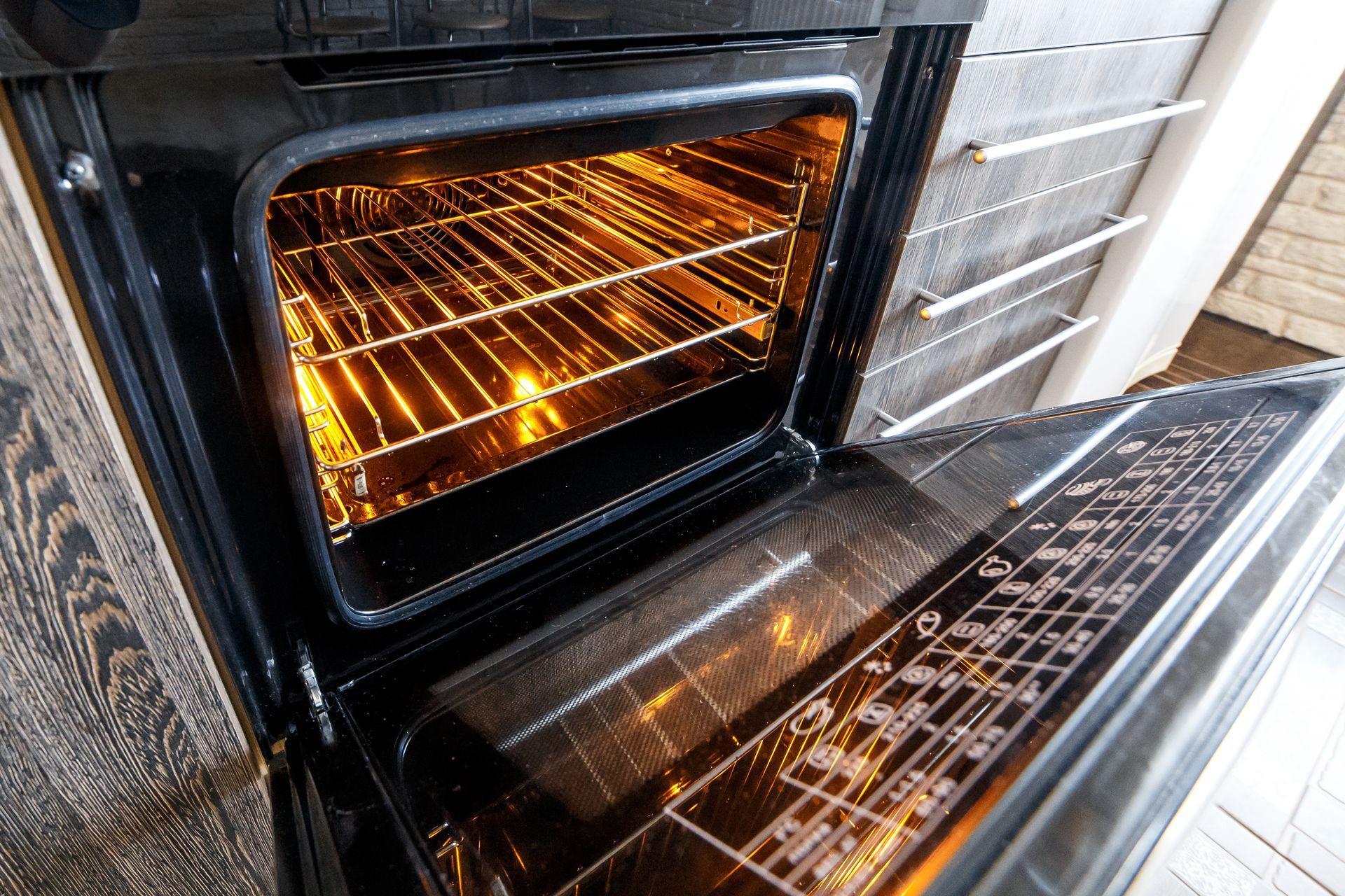 An oven with an open door and interior light. The shelves are visible.