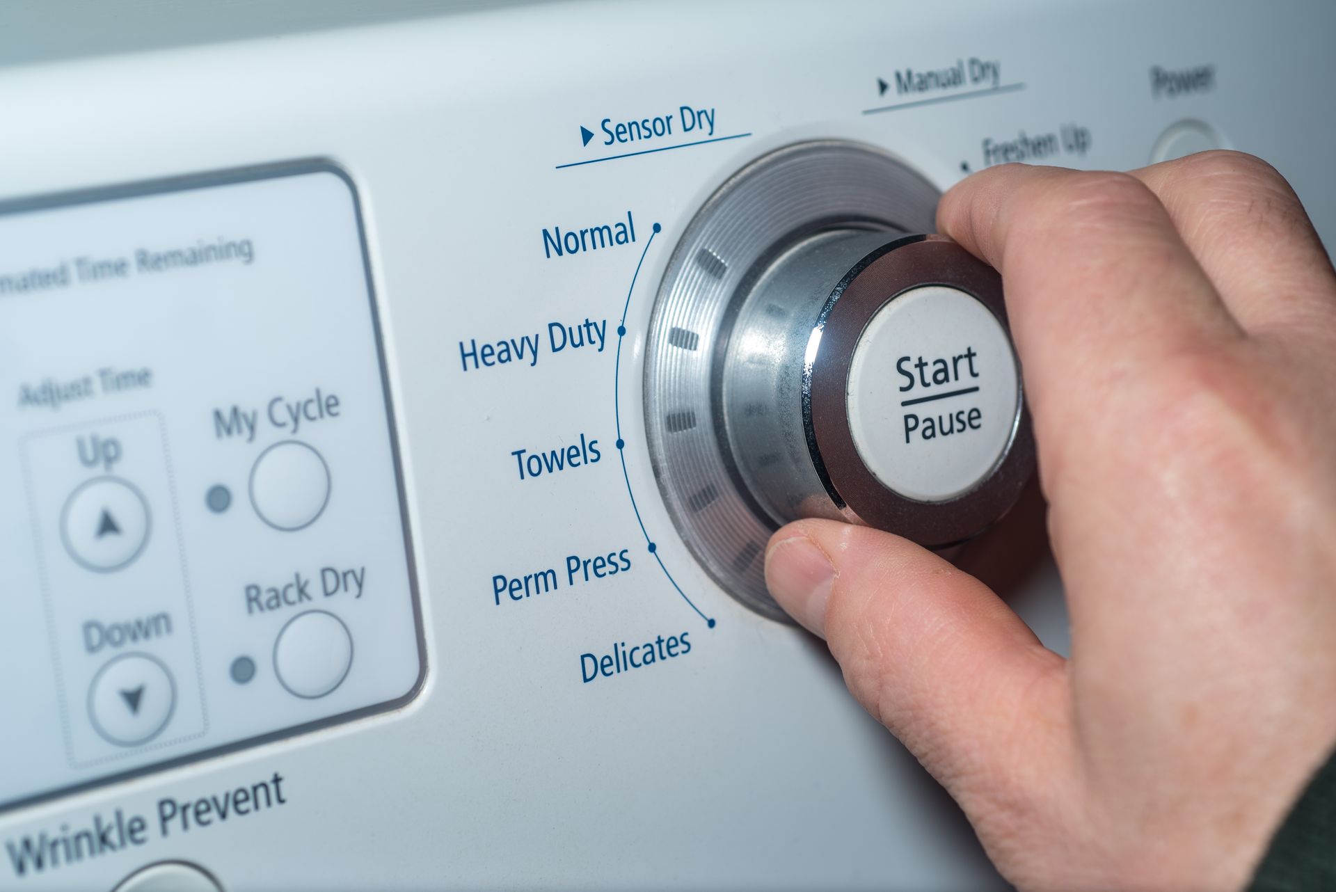 Person in yellow gloves inserts a metal heating element into a washing machine.