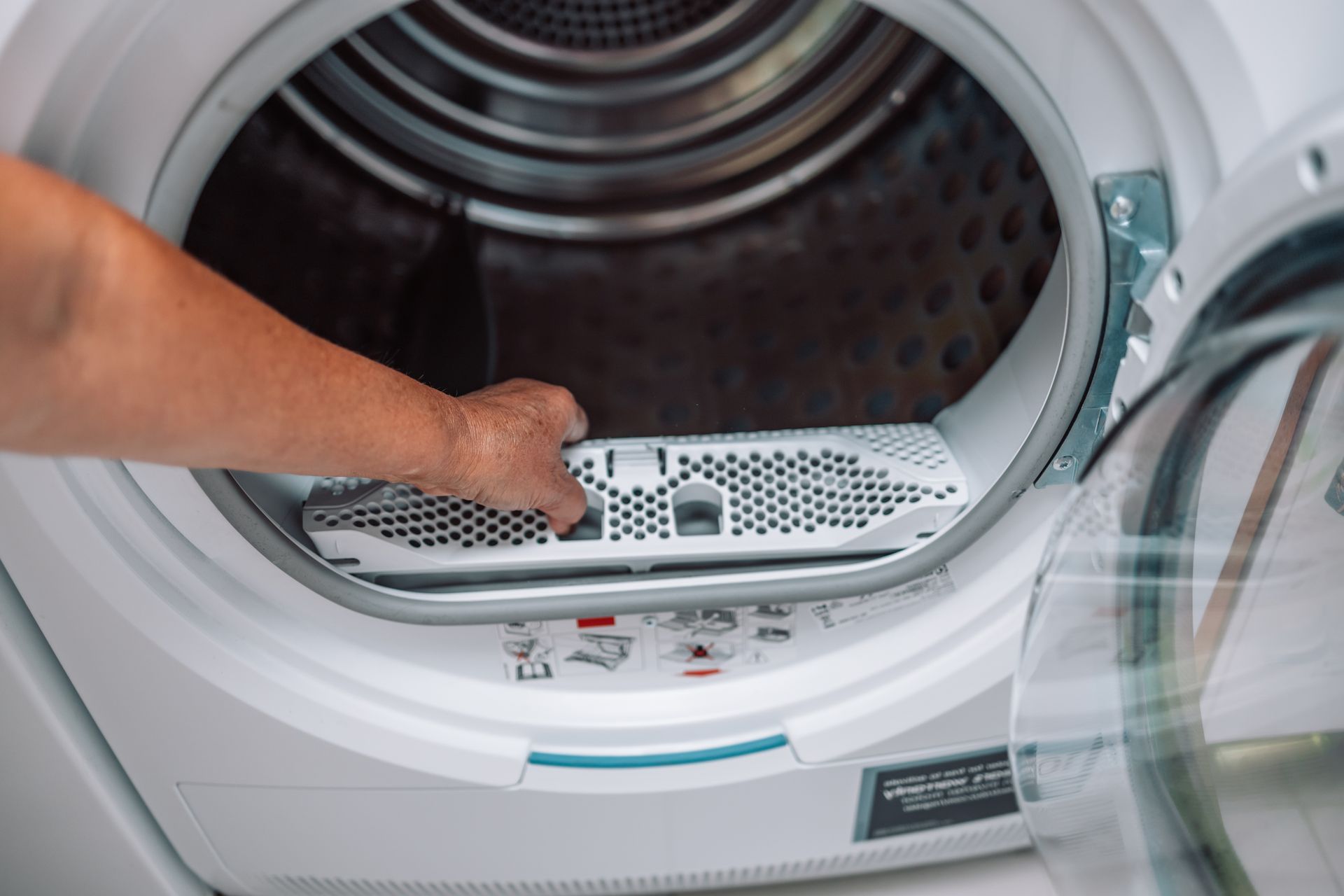 Person cleaning the lint filter of a dryer.