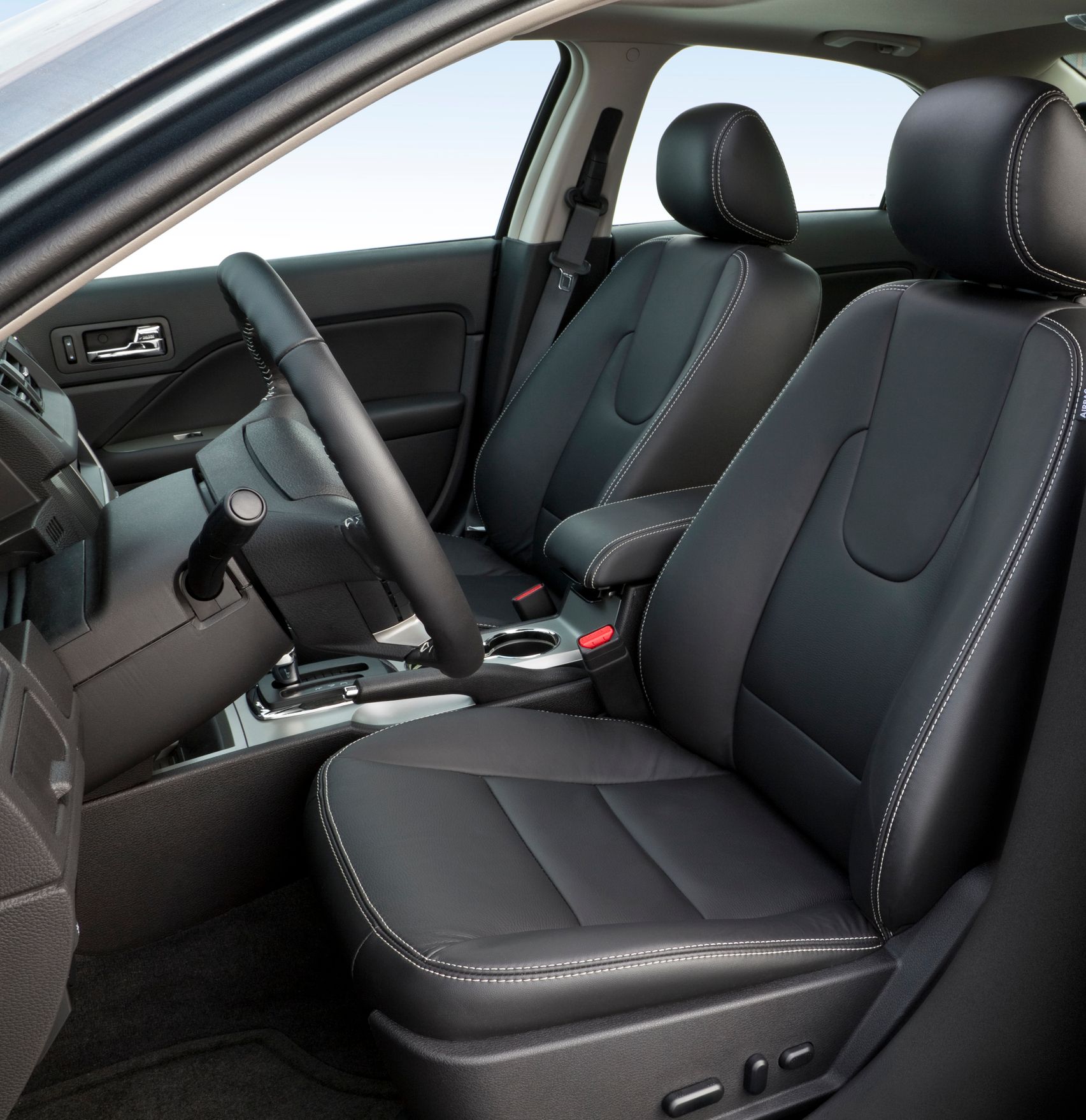 The inside of a car with black seats and a steering wheel