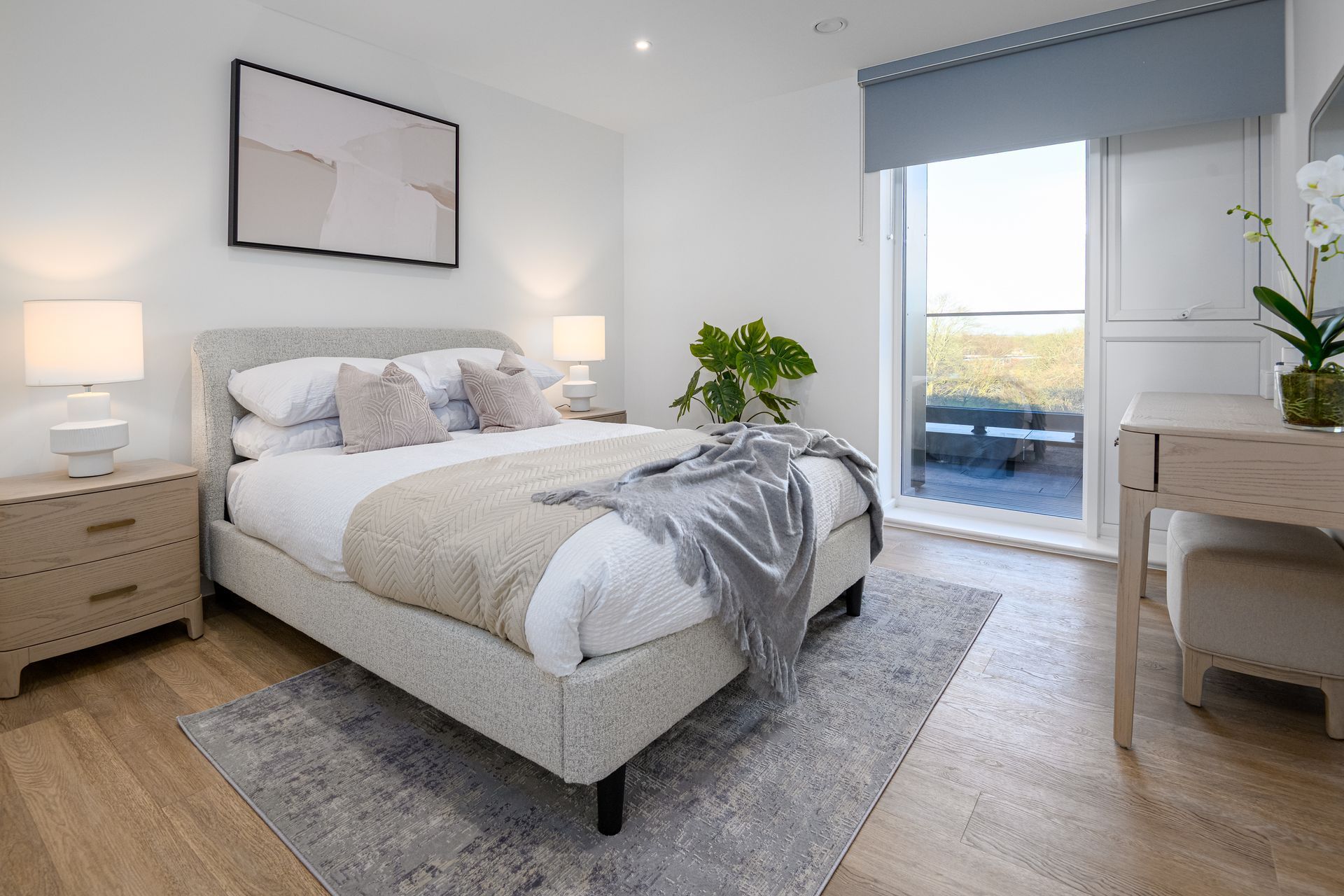 A bedroom with a large bed , nightstands , lamps and a balcony.