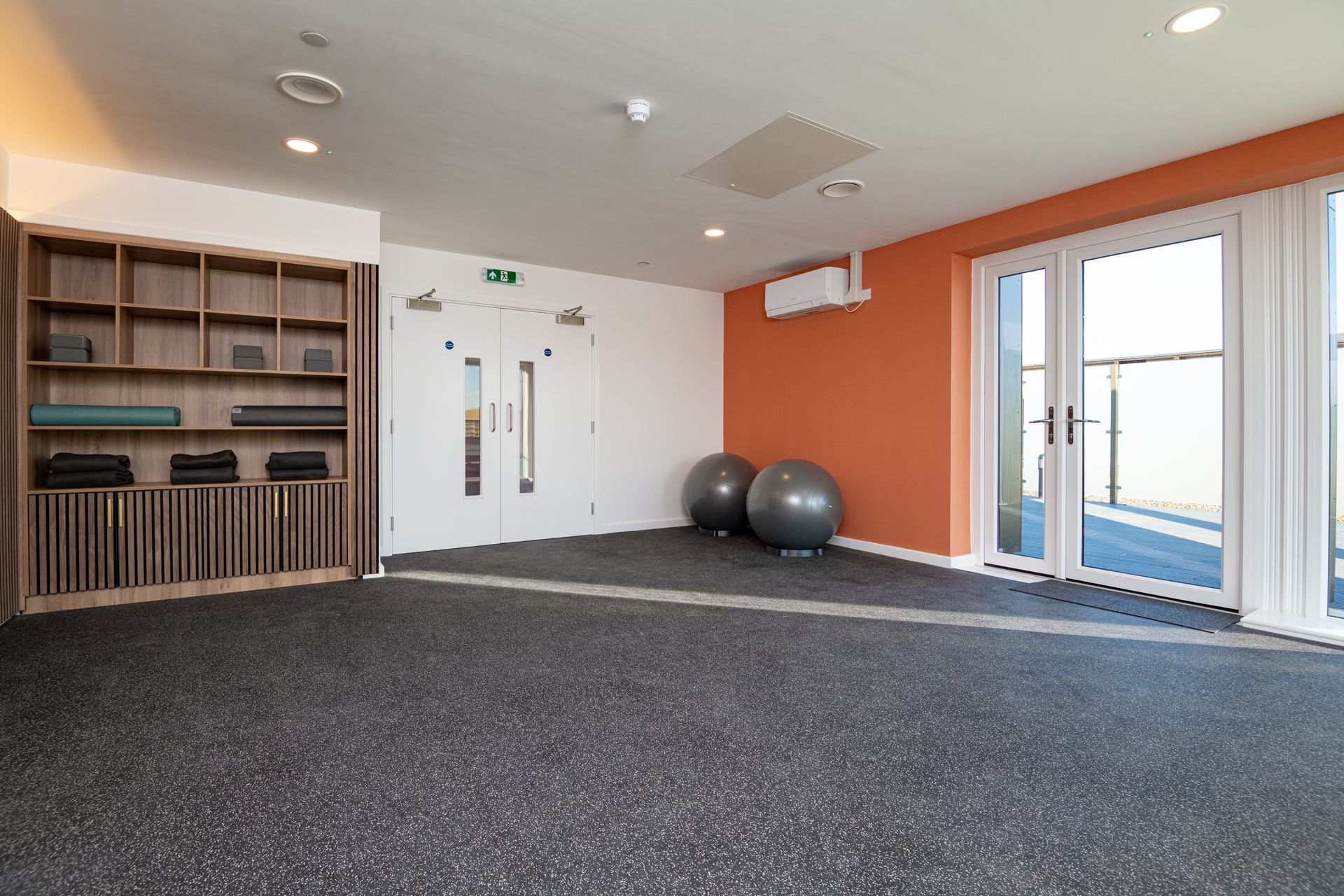 There are two exercise balls in the middle of the room.