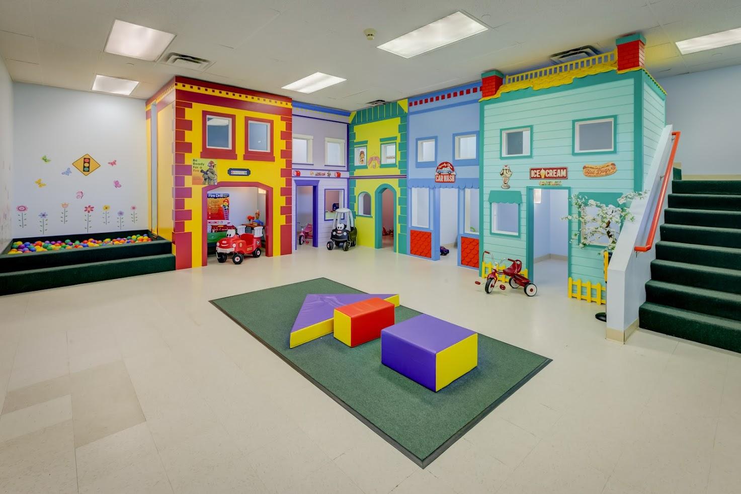 A room with a lot of toys and stairs in it.
