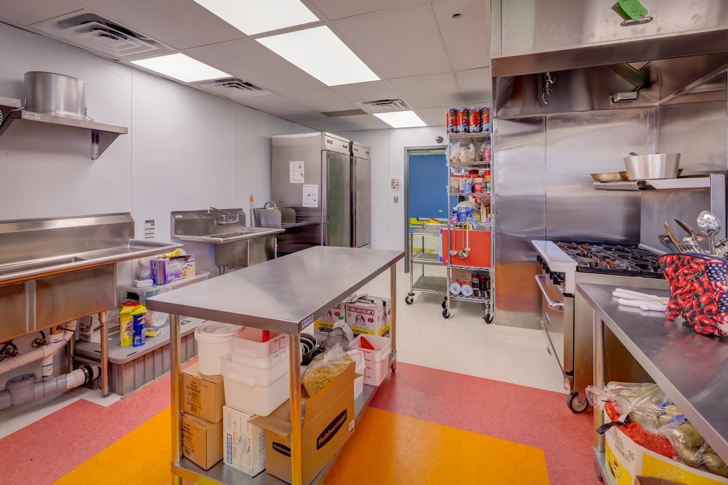 A kitchen with stainless steel appliances and a large table.