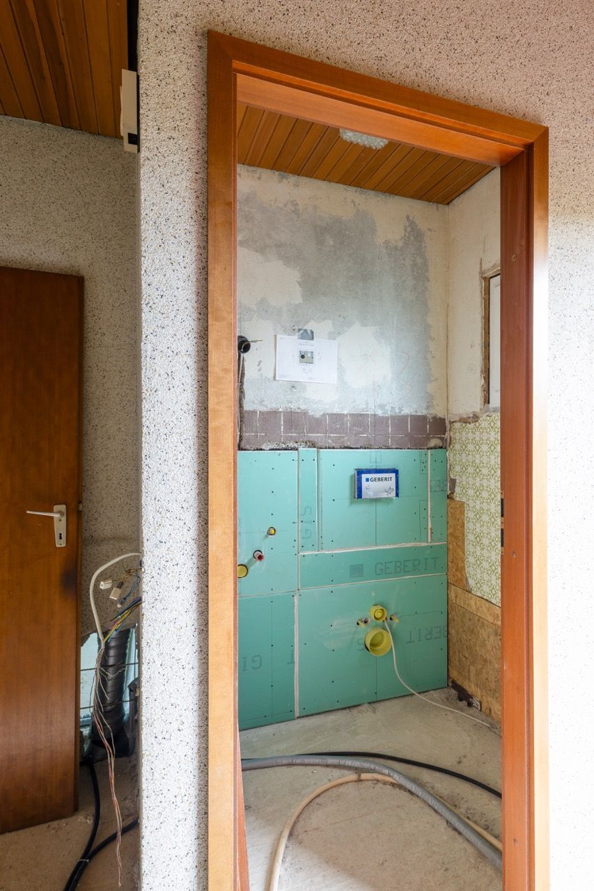 Teilweise gefliestes Badezimmer im Umbau mit Duschnische und freiliegenden Wänden