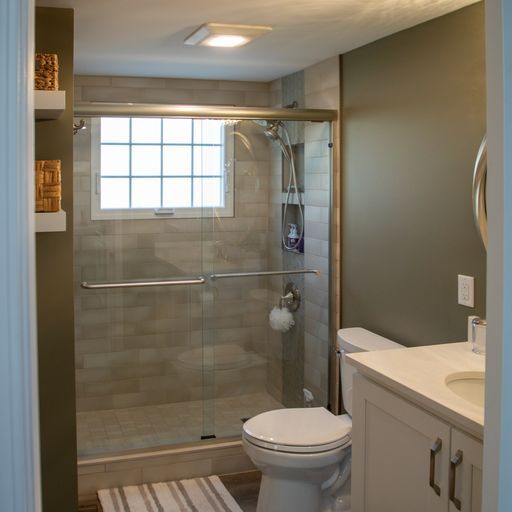 Modern bathroom with shower, toilet, and vanity. Beige tile, olive green walls.
