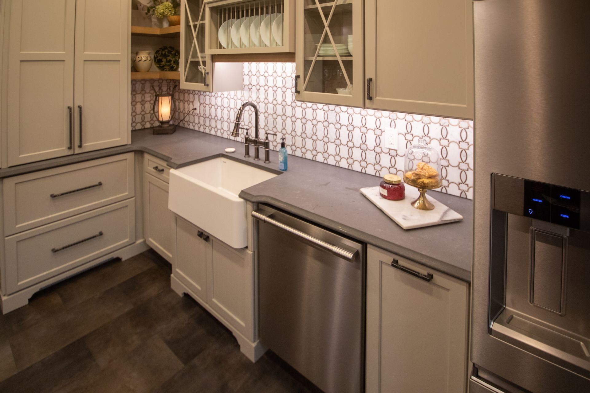 Kitchen with light green cabinets, white farmhouse sink, and stainless steel appliances.