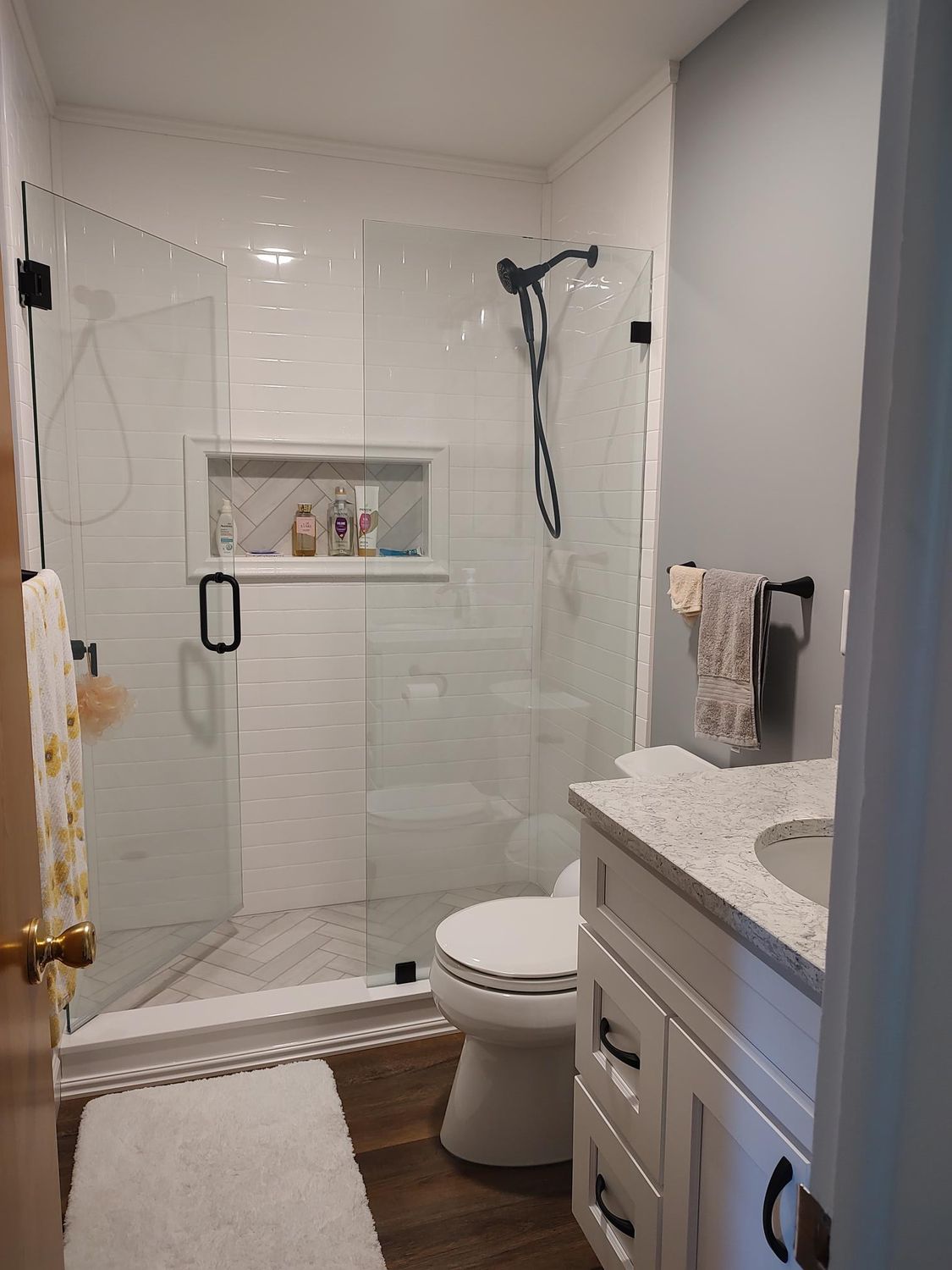 Modern bathroom with glass shower, white subway tile, and a white vanity.