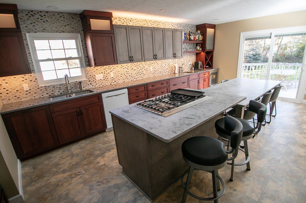 Modern kitchen with island, cooktop, seating, and cabinetry.
