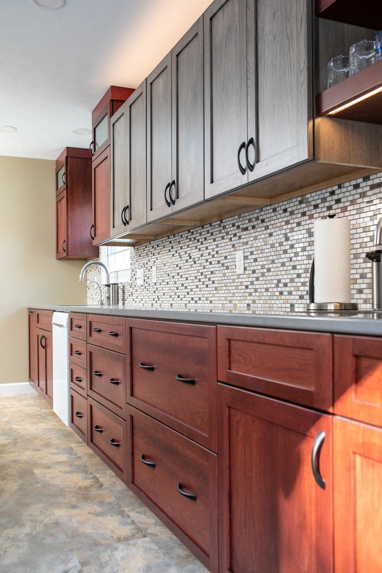 Kitchen with dark wood cabinets, gray countertops, and mosaic tile backsplash.