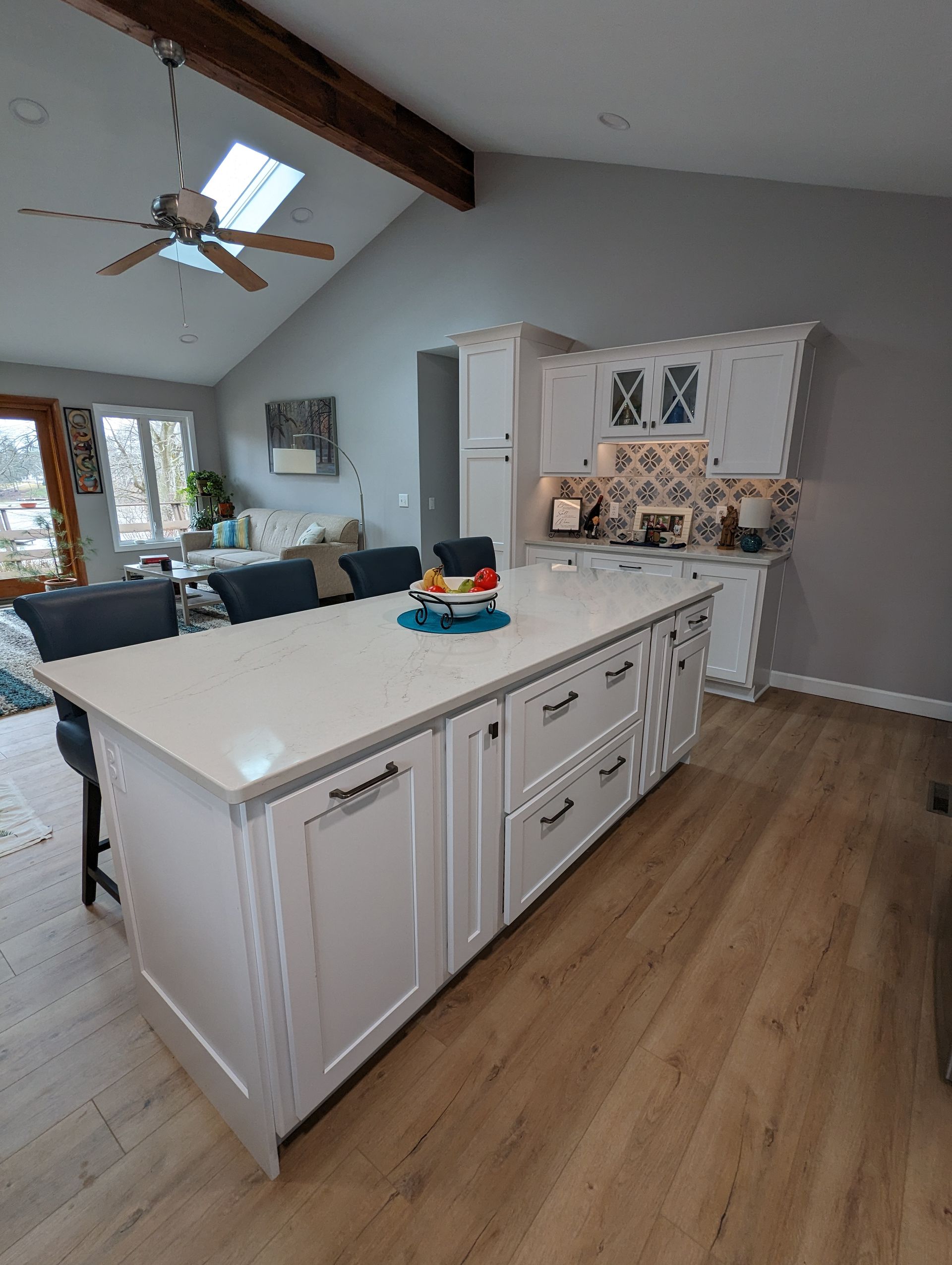White kitchen island with countertop, cabinets, and drawers in a modern home.