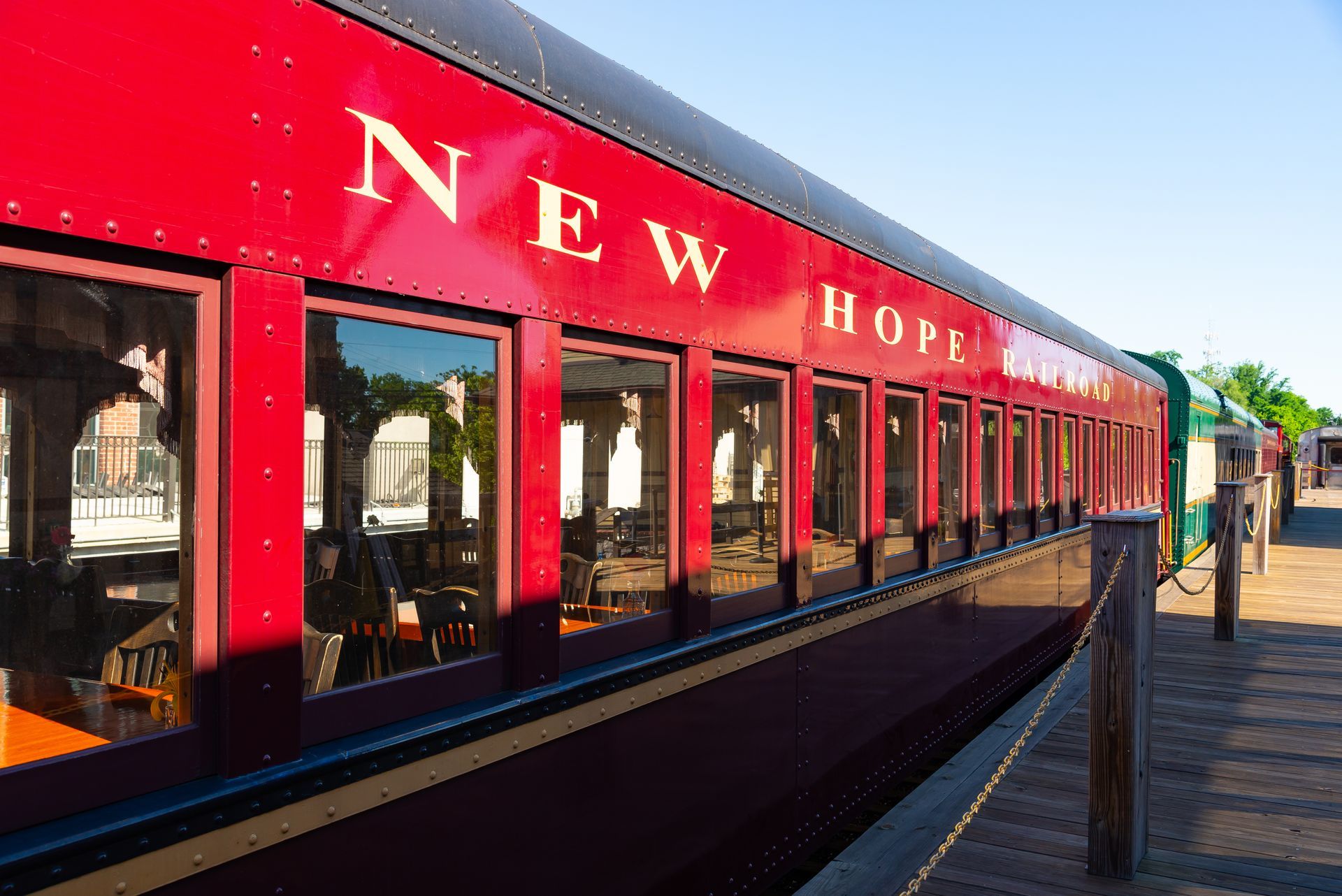 Red New Hope train car at a sunny station platform