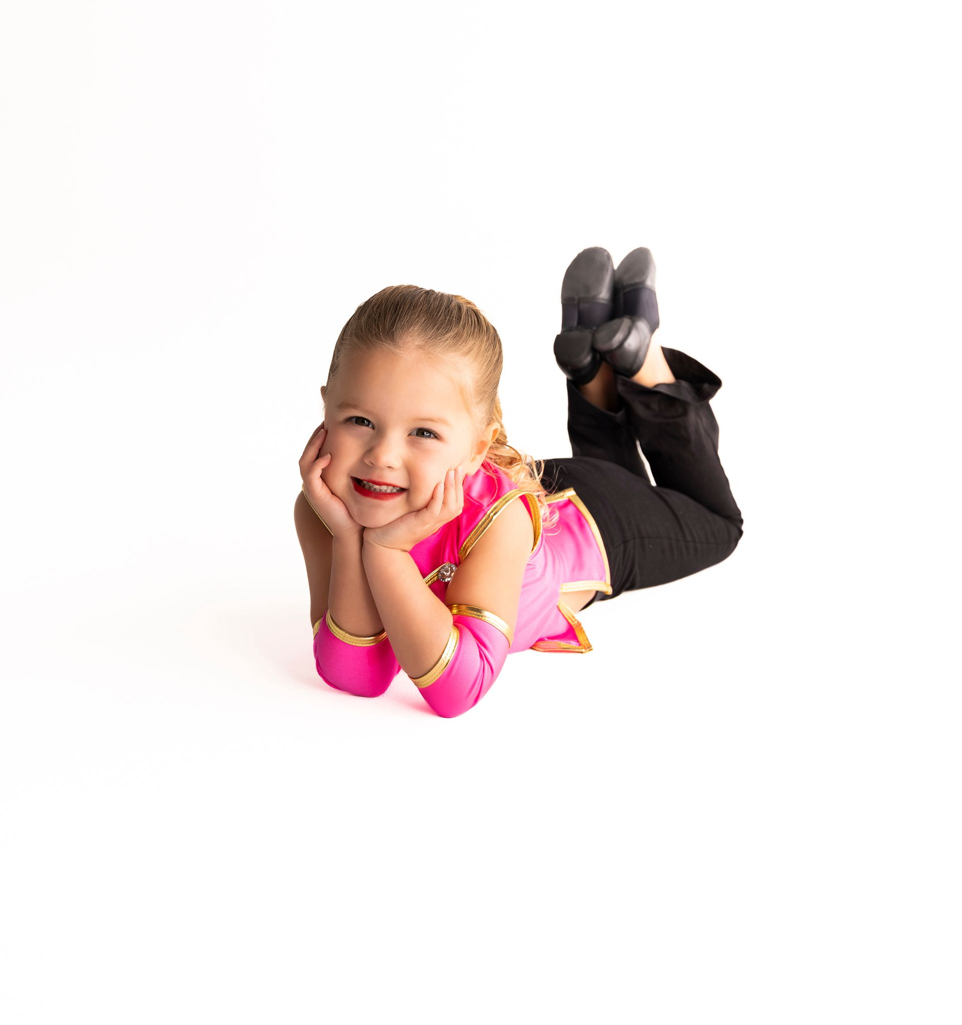 Young girl in dance attire, smiling, lying on her stomach — iDance Performance Co In Medowie, NSW
