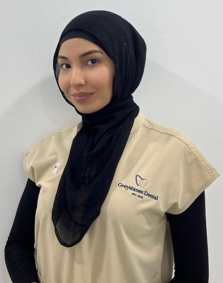 A woman wearing a hijab and a dental uniform A woman wearing a hijab and a dental uniform