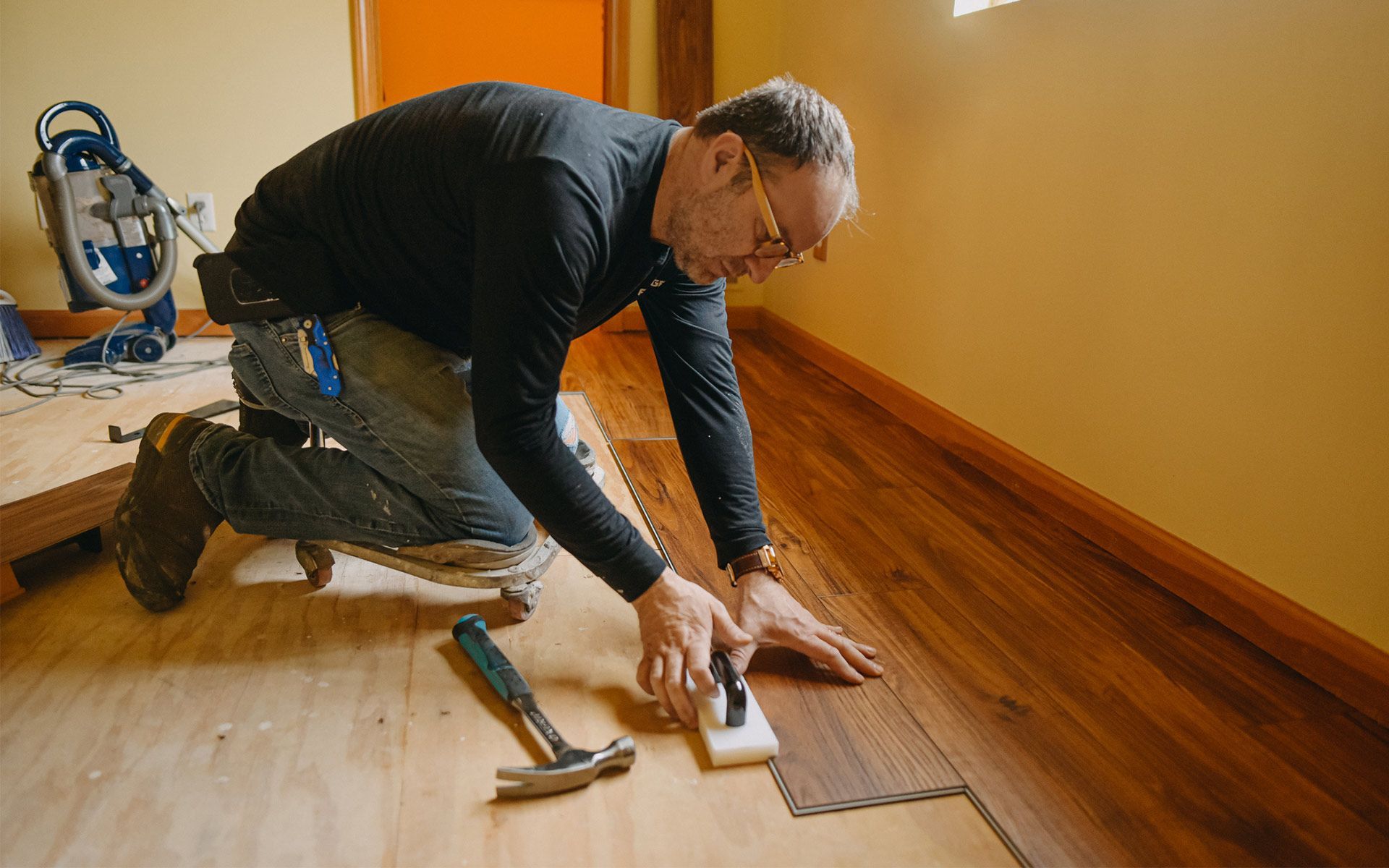 Man installing wood flooring.