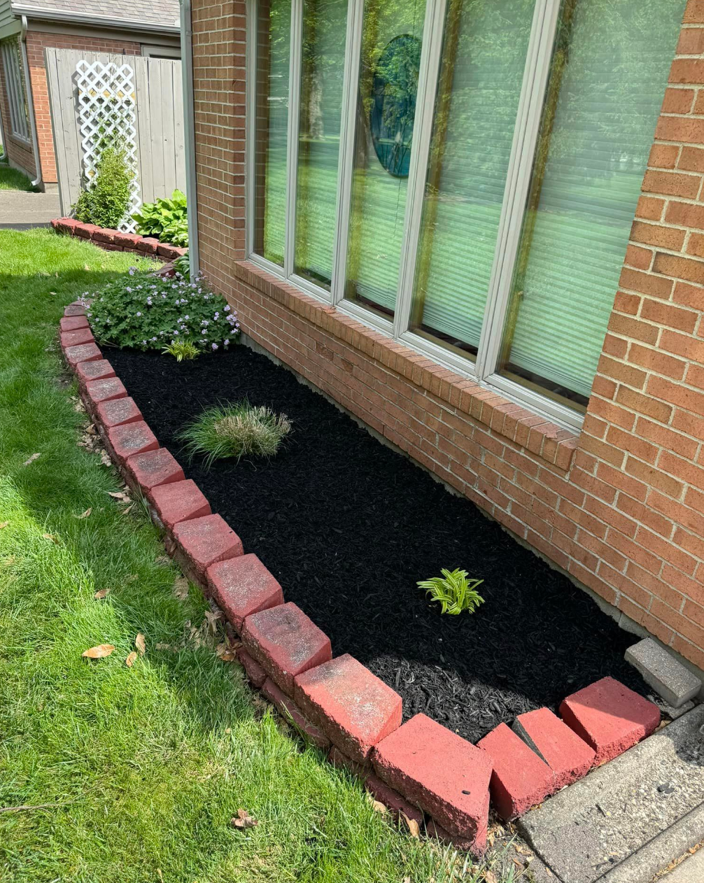A brick house with a garden in front of it.