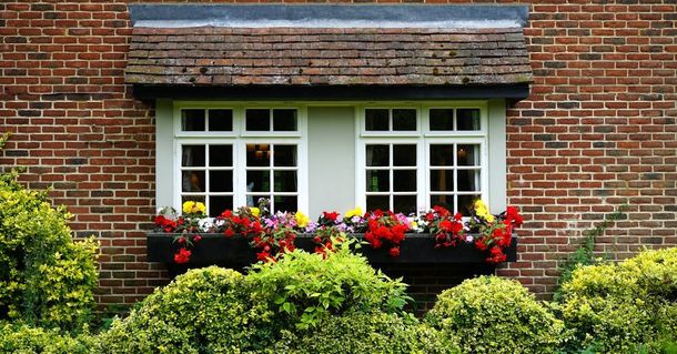 A brick house with a window with flowers in it