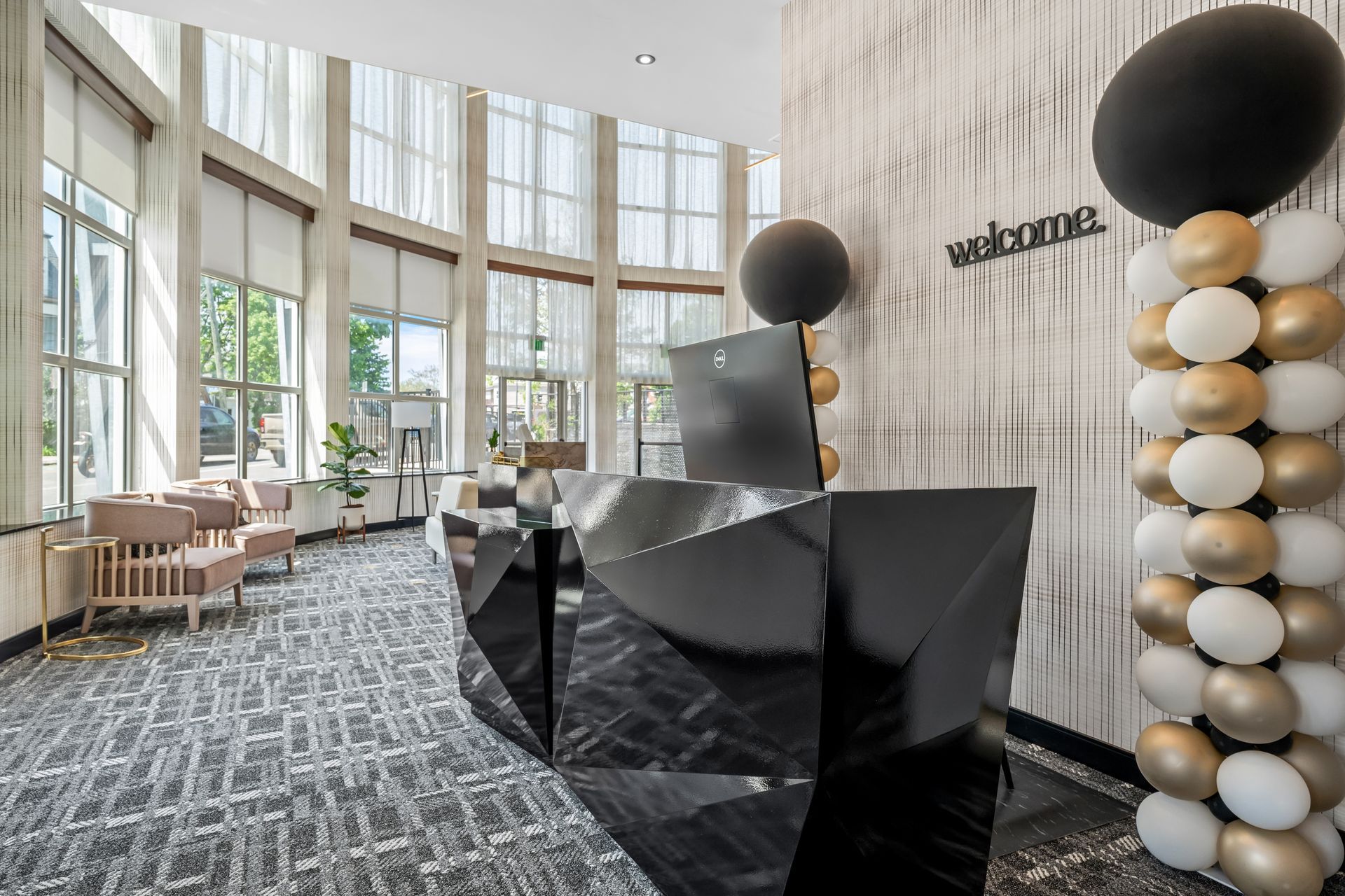 Modern hotel lobby with geometric black reception desk, tall windows