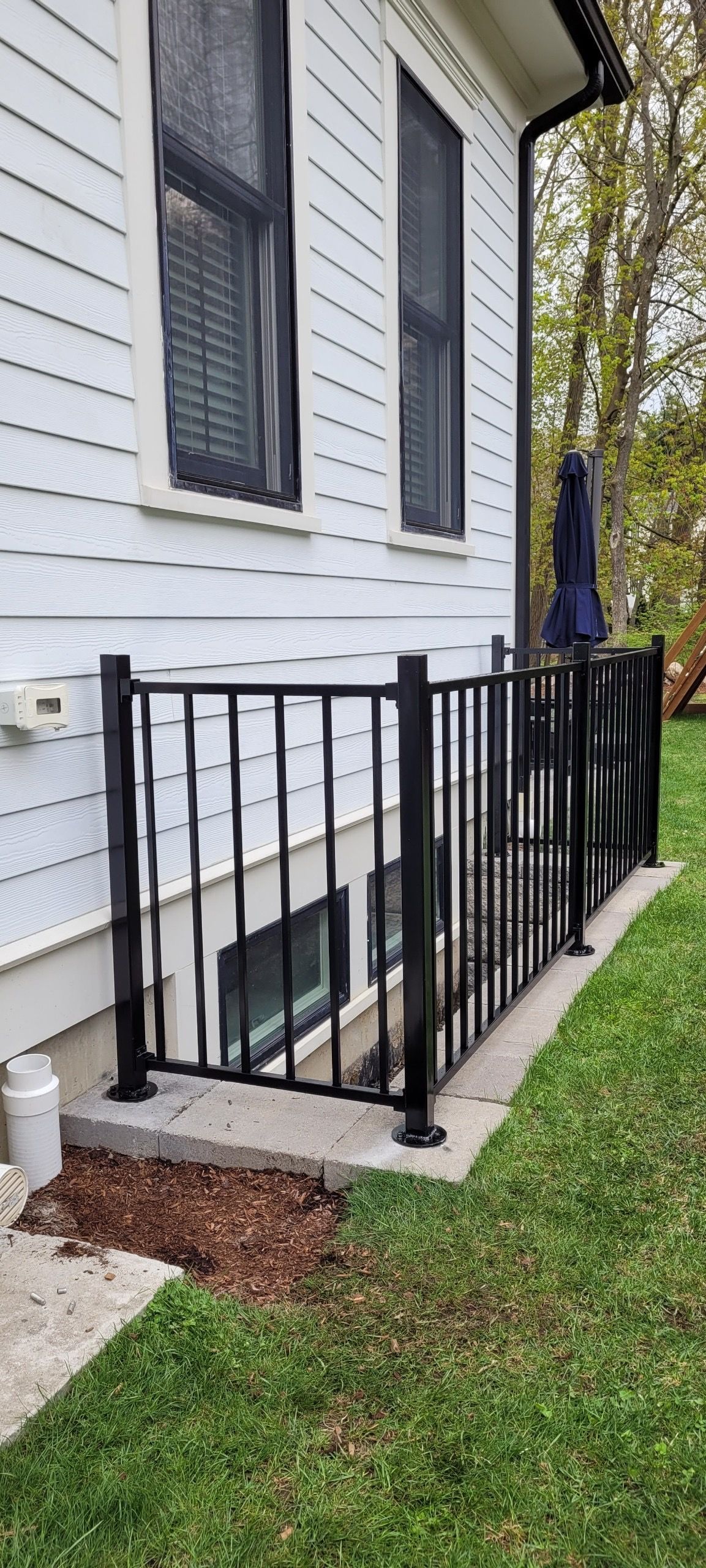 A white house with a black railing on the side of it.
